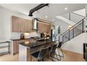 Elegant kitchen with island, modern cabinets, granite counters, stainless appliances, and open staircase at 1242 Yates St # U2, Denver, CO 80204