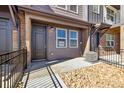 Inviting townhome entrance with a modern door, landscaping, and walkway at 6850 Merseyside Ln, Castle Pines, CO 80108