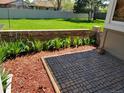 A lush backyard with a brick wall, flower bed, mulch, and grass, perfect for relaxing or entertaining guests at 2619 S Iris Ct, Lakewood, CO 80227