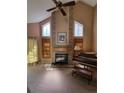 Bright living room with a fireplace, piano, and large windows, ideal for cozy gatherings and showcasing a musical talent at 2619 S Iris Ct, Lakewood, CO 80227