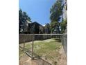 Backyard view with grass and gravel, surrounded by a chain link fence at 1901 N Emerson St, Denver, CO 80218