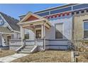 This home features a covered porch, painted brick, and an inviting entryway at 1157 N Downing St, Denver, CO 80218