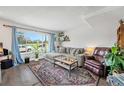 Inviting living room with large window, comfortable gray couch, plants, and colorful rug, creating a cozy atmosphere at 8666 Mariposa St, Thornton, CO 80260