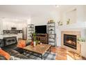 Open living room leading to the kitchen features a fireplace and wood floors at 4085 S Crystal Cir # 104, Aurora, CO 80014