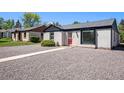 Charming exterior with gray stucco, black trim, red door, and gravel yard at 1355 Rosemary St, Denver, CO 80220