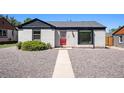 Charming exterior with gray stucco, black trim, and a red front door at 1355 Rosemary St, Denver, CO 80220