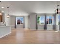 Bright living room featuring gorgeous hardwood floors and plenty of natural light from the three large windows at 17186 E Cedar Gulch Dr, Parker, CO 80134