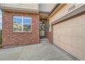 Inviting front entrance with a brick facade, garage, and well-manicured landscaping at 1710 S Poplar St, Denver, CO 80224