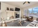 Cozy living room featuring a fireplace, mantel, and large windows offering ample natural light at 1710 S Poplar St, Denver, CO 80224