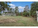 Expansive backyard showcasing a well-maintained lawn and mature trees creating a peaceful outdoor space at 4295 Picutis Rd, Indian Hills, CO 80454