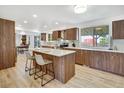 Modern kitchen features sleek wood cabinetry, stainless steel appliances, and a central island with seating at 8095 Johnson Ct, Arvada, CO 80005