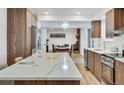 This kitchen boasts an island with seating, modern appliances, and an open design leading to the dining and living areas at 8095 Johnson Ct, Arvada, CO 80005