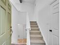 Bright entryway featuring carpeted stairs, stone flooring, and white walls at 7077 S Bryant St, Littleton, CO 80120