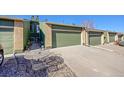 Attached garage with a long driveway and stone landscaping and table with chairs at 7077 S Bryant St, Littleton, CO 80120