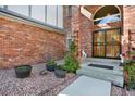 Brick home entrance featuring a secured doorway, potted plants, and decorative rock landscaping at 16627 W 1St Ave, Golden, CO 80401
