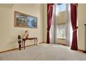 Living room featuring soaring ceilings, large windows with bright natural light and decorative red curtains at 16627 W 1St Ave, Golden, CO 80401