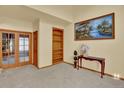 Living room with French doors, custom wood bookshelf, and a serene painting above a console table at 16627 W 1St Ave, Golden, CO 80401