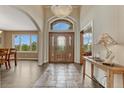 Inviting home foyer with hardwood floors, decorative front door, and a large window at 1127 Buttermilk Rd, Larkspur, CO 80118