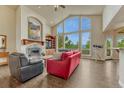Bright living room with a fireplace, hardwood floors, and a large scenic window at 1127 Buttermilk Rd, Larkspur, CO 80118
