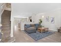 Inviting living room featuring an open floor plan, hardwood floors, modern decor, and a staircase at 24738 E Layton Pl, Aurora, CO 80016