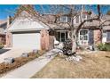Inviting two-story brick home with a manicured lawn and a two-car garage at 6023 E Briarwood Dr, Centennial, CO 80112