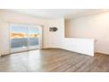 Bright, empty living room with hard surface floors, sliding door to balcony, and white walls at 912 S Yampa St # 206, Aurora, CO 80017