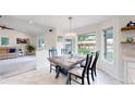 Cozy dining area with a wooden table, seating for six, and large windows at 10886 Pheasant Run, Littleton, CO 80125