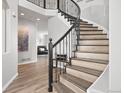 Elegant staircase features wrought iron railing, wood steps, and a 'welcome' decor at 1788 Alpine Dr, Erie, CO 80516