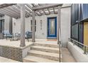 Front entryway featuring a blue door, modern lighting, and a covered porch at 1819 W 32Nd Ave, Denver, CO 80211
