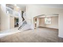 Bright and airy living room featuring soaring ceilings, carpeted floors, and a staircase with white railings at 11305 W Crestline Dr, Littleton, CO 80127