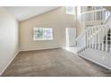 Bright living room with vaulted ceilings, neutral walls, large windows, and carpeted flooring at 11305 W Crestline Dr, Littleton, CO 80127