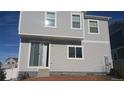 Rear view of a two-story house featuring sliding glass doors and a patio at 20108 Randolph Pl, Denver, CO 80249