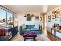 Living room with teal couch and wood floors, featuring gallery wall at 4330 Bruce Randolph Ave, Denver, CO 80207