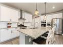 Modern kitchen featuring white cabinets, granite countertops, stainless steel appliances, and a large island at 599 Fall River Ct, Brighton, CO 80601