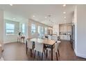 Open concept dining area with modern light fixtures that flows into a large, bright kitchen at 6880 Bryant Way, Denver, CO 80221