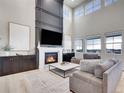Stunning living room featuring a cozy fireplace, elegant decor, and large windows providing plenty of natural light at 7012 S Undergrove Way, Aurora, CO 80016