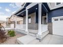 Inviting covered porch with white pillars offers a welcoming entry to this charming home at 8374 E 132Nd Pl, Thornton, CO 80602