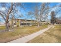 Low angle view of multi-Gathering residence featuring mature trees and lush landscaping at 710 S Clinton St # 6A, Denver, CO 80247