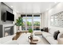 Bright living room with fireplace, large windows, and a comfortable seating area at 333 S Monroe St # 211, Denver, CO 80209