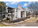 A beautiful building exterior with unique design elements, mature trees, and manicured grounds at 17505 E Mansfield Ave # 1411L, Aurora, CO 80013
