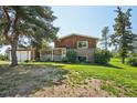 Charming two-story brick home featuring a well-maintained lawn and a classic front porch at 8840 Niwot Rd, Niwot, CO 80503