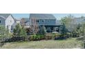 Scenic view of the backyard, showcasing mature trees, a fenced-in lawn, and a charming pergola at 7665 Grady Cir, Castle Rock, CO 80108