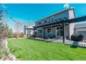 Beautiful backyard featuring a large lawn and a covered patio with outdoor furniture at 7665 Grady Cir, Castle Rock, CO 80108