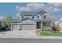 Charming two-story home featuring a three-car garage, well-manicured lawn, and inviting front porch at 7665 Grady Cir, Castle Rock, CO 80108