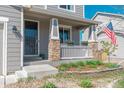 Inviting front porch with stone accents, a white railing, and tasteful landscaping at 7665 Grady Cir, Castle Rock, CO 80108
