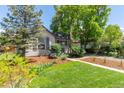 Quaint single-story home with lush green lawn and mature trees at 4712 Perry St, Denver, CO 80212