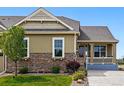 Charming exterior with stone accents, manicured lawn and inviting front porch at 7426 E 148Th Pl, Thornton, CO 80602