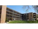 Apartment building with balconies, a grassy area, and a fence at 800 W Belleview Ave # 407, Englewood, CO 80110