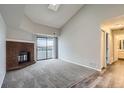 Bright living room featuring a skylight, fireplace, carpet, and glass sliding door to the patio at 14437 E 1St Dr # C09, Aurora, CO 80011