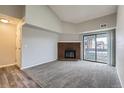 Spacious living room with a fireplace, high ceiling and a sliding glass door leading to a balcony at 14437 E 1St Dr # C09, Aurora, CO 80011